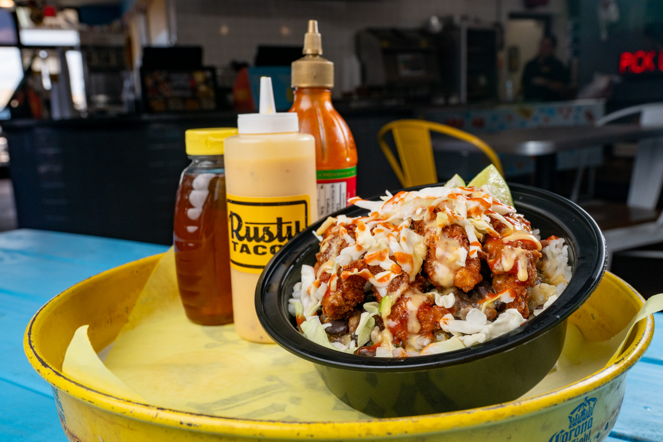 The Uptown Taco Bowl with crispy chicken, queso, slaw, honey and sriracha